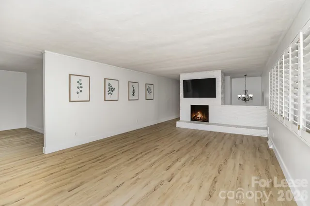 a view of empty room with wooden floor and fireplace