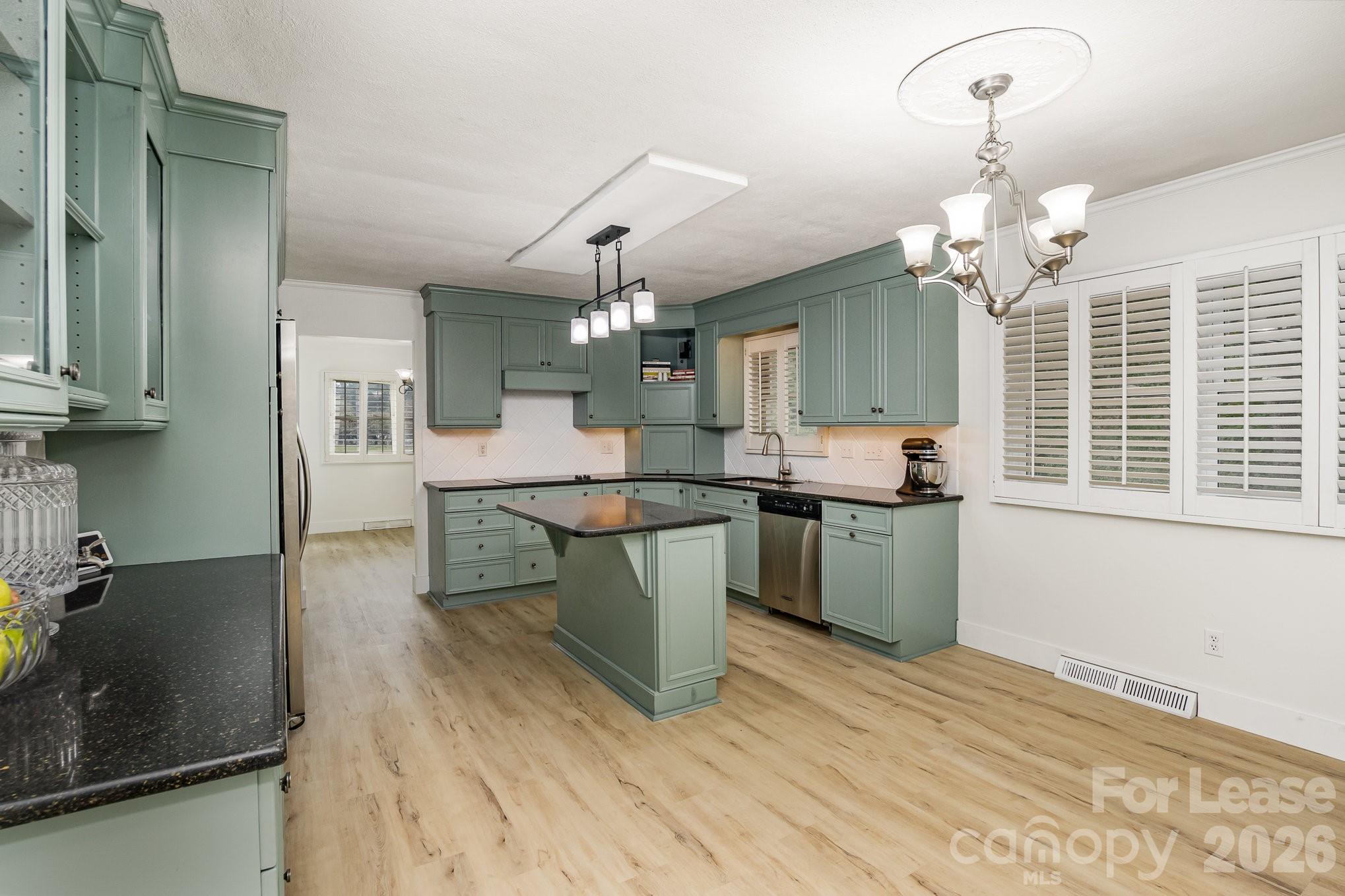 7407 Forney Hill Road Denver, NC 28037 - Photo 5 of 10 a kitchen with granite countertop white cabinets and stainless steel appliances