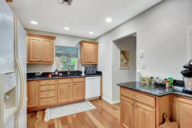 a kitchen with stainless steel appliances granite countertop a sink stove and refrigerator