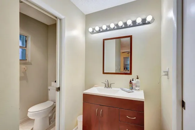 a bathroom with a toilet sink and mirror