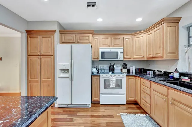 a kitchen with stainless steel appliances granite countertop a refrigerator sink and cabinets