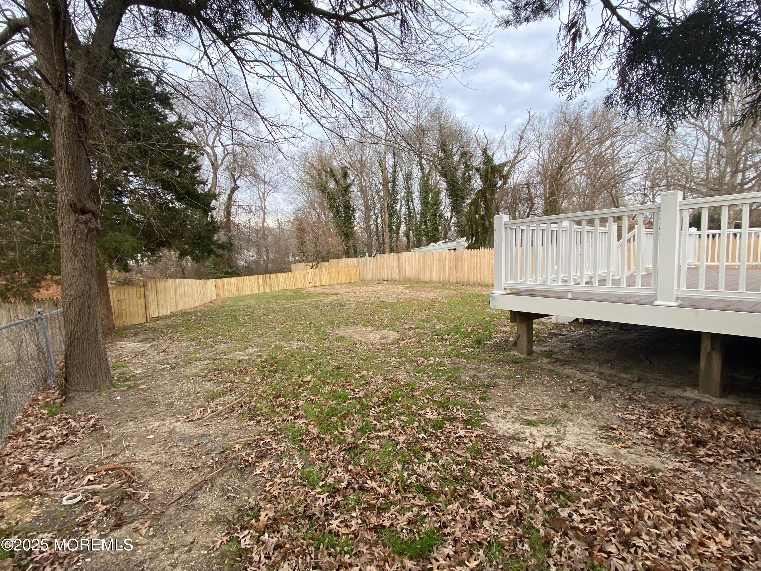 122 West 6th Street Howell, NJ 07731 - Photo 16 of 16 a view of a yard with wooden fence and large trees