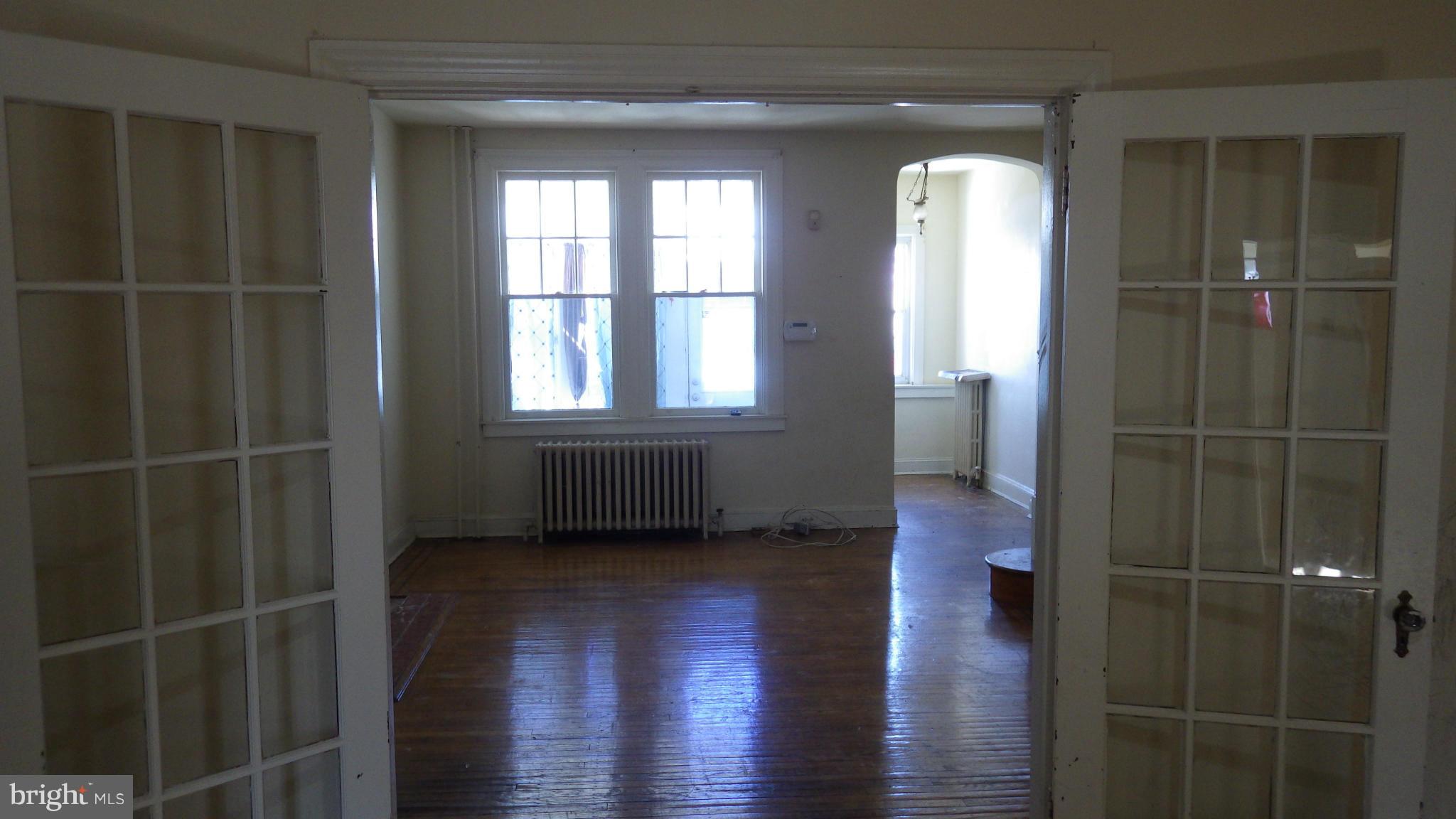 6055 Harford Road Baltimore, MD 21214 - Photo 1 of 13 a view of an empty room with wooden floor and a window