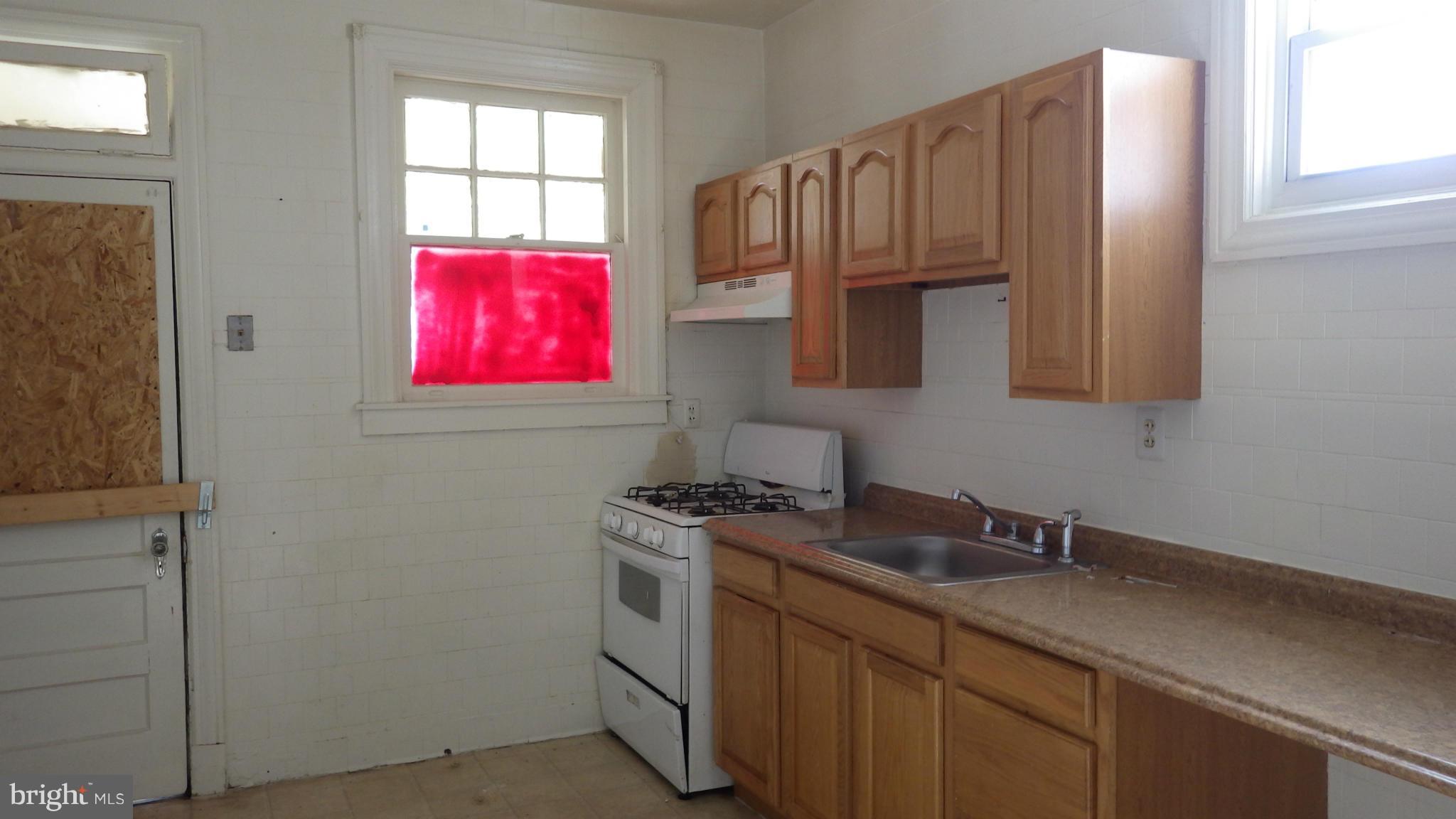 6055 Harford Road Baltimore, MD 21214 - Photo 2 of 13 a kitchen with stainless steel appliances granite countertop a sink a stove and cabinets