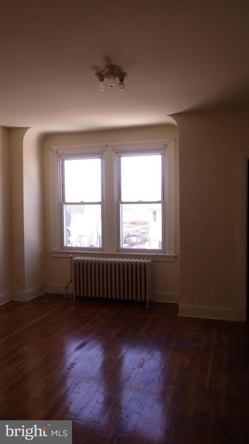 6055 Harford Road Baltimore, MD 21214 - Photo 5 of 13 an empty room with wooden floor and windows