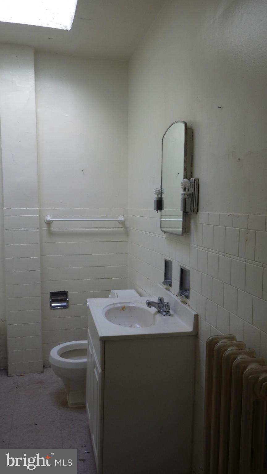 6055 Harford Road Baltimore, MD 21214 - Photo 7 of 13 a bathroom with a sink toilet and vanity