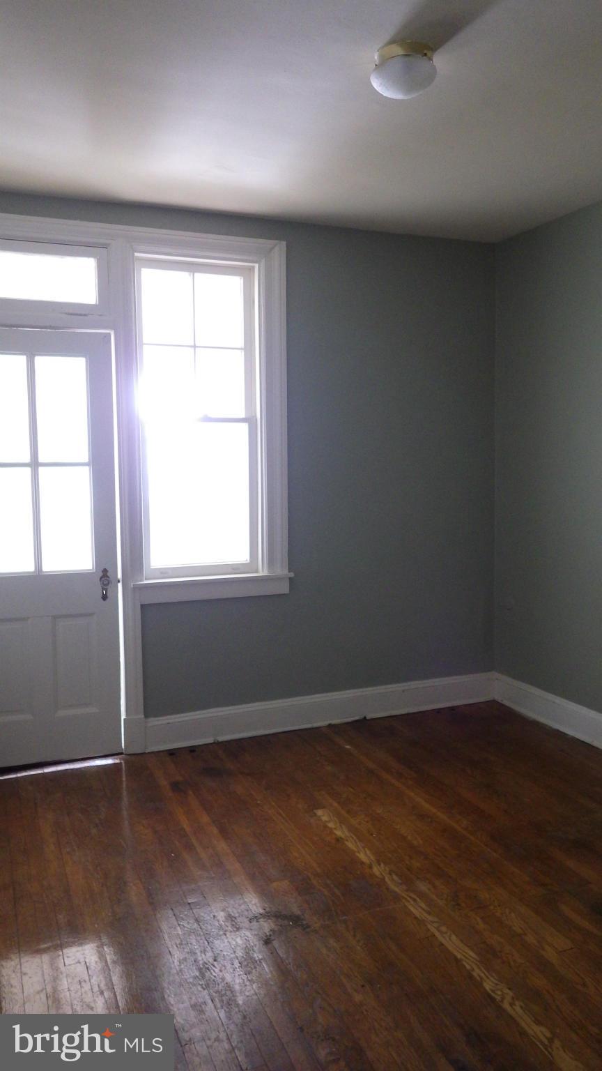 6055 Harford Road Baltimore, MD 21214 - Photo 8 of 13 an empty room with wooden floor and windows