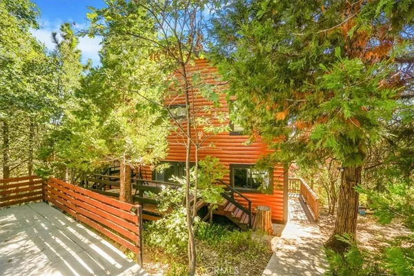 a view of a yard with plants and wooden bench