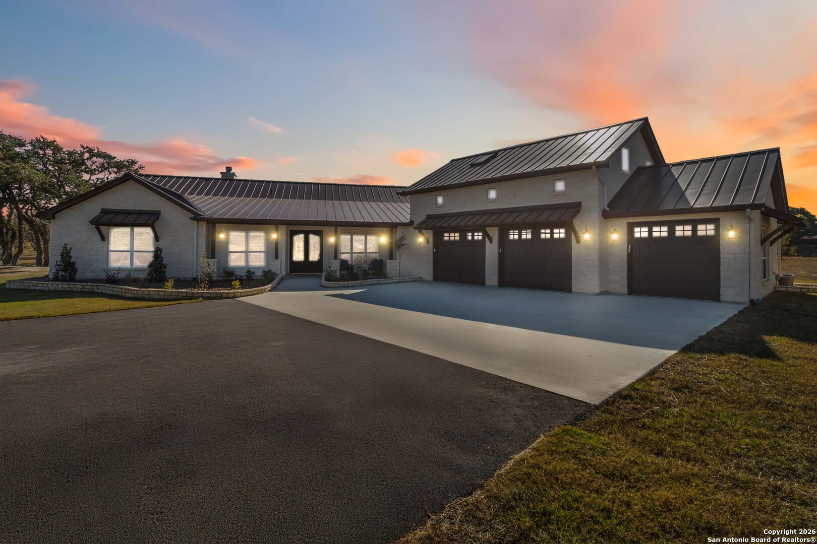 a front view of a house with a yard and potted plants
