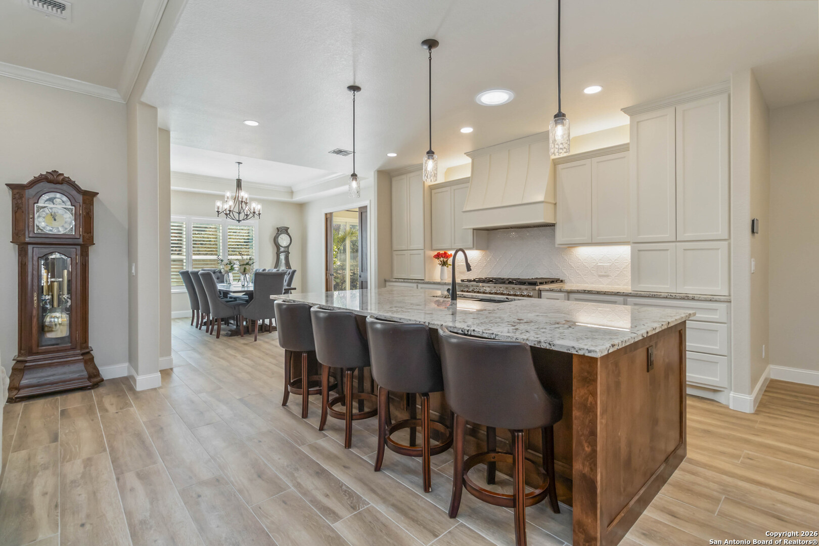 43 Lost Valley Boerne, TX 78006 - Photo 12 of 61 a kitchen with granite countertop a table chairs a sink dishwasher refrigerator and cabinets with wooden floor