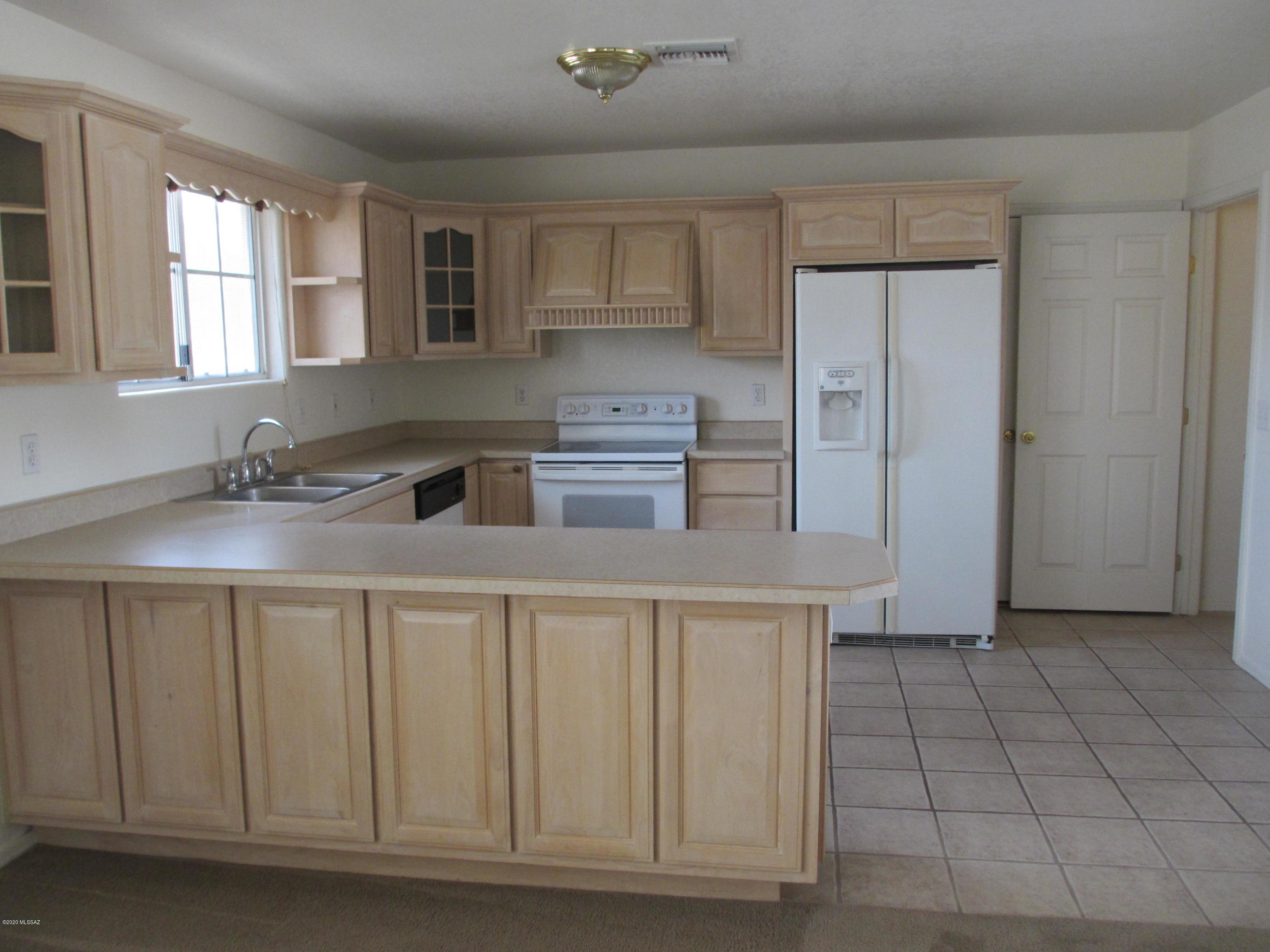 453 Chalet Court Rio Rico, AZ 85648 - Photo 10 of 26 a kitchen with stainless steel appliances a sink stove and cabinets
