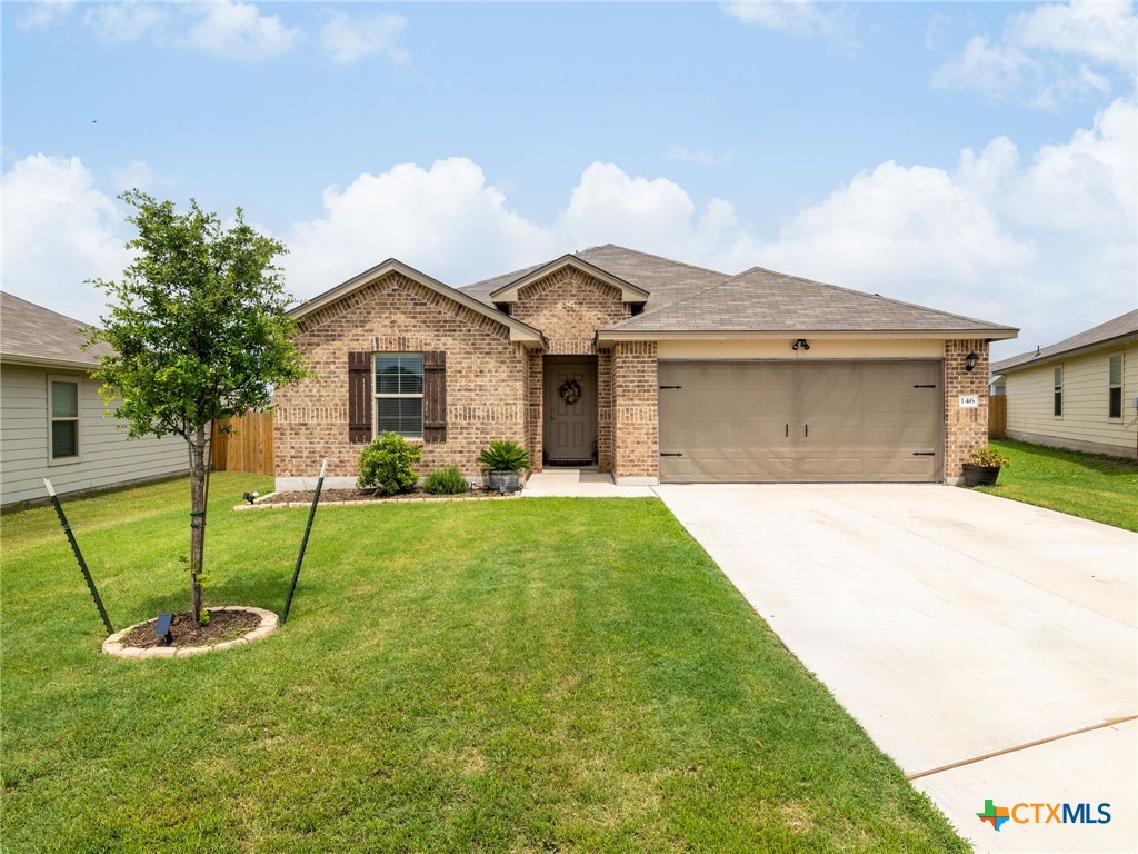 a front view of a house with a yard and garage