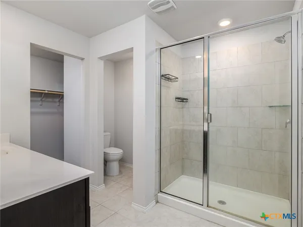 a bathroom with a shower a toilet and a sink