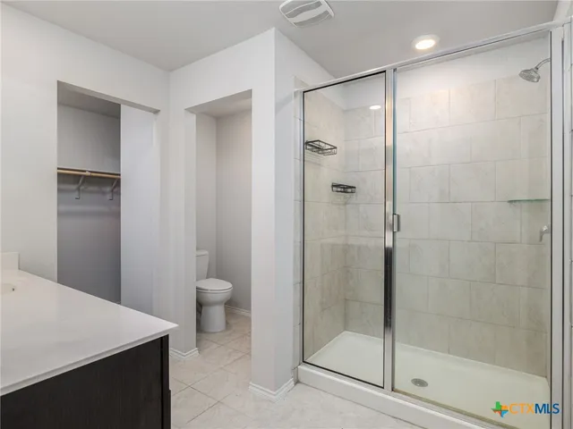 a bathroom with a shower a toilet and a sink