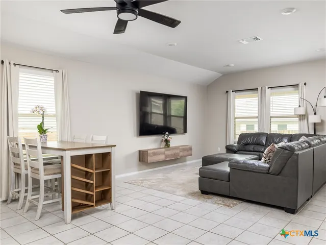 a living room with furniture a flat screen tv and a window