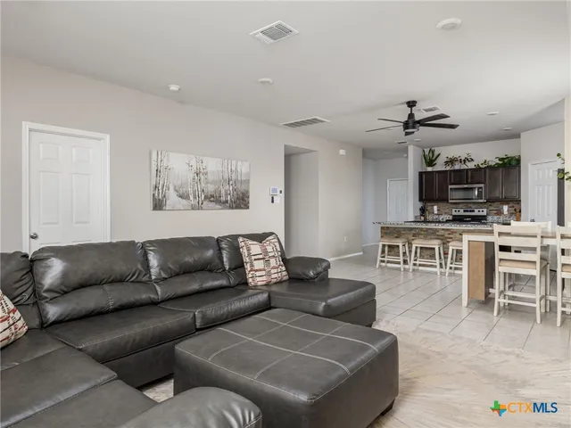 a living room with furniture and a view of kitchen