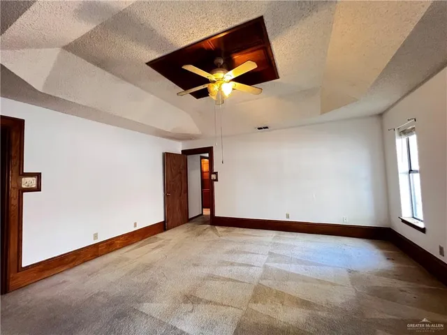 an empty room with fan and windows