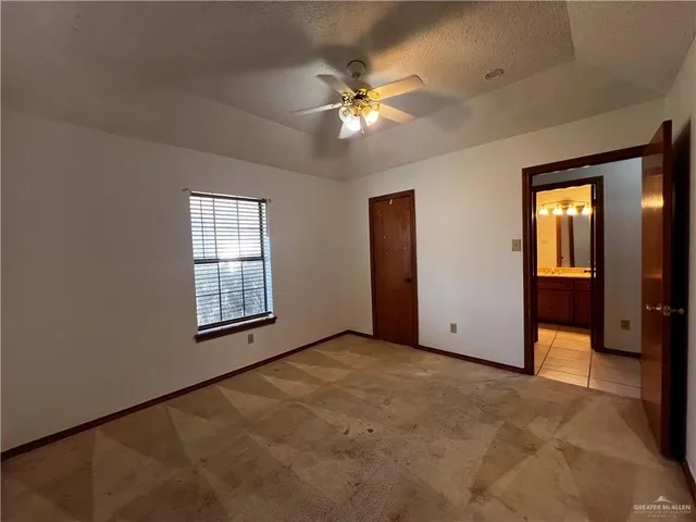 an empty room with a ceiling fan and a window
