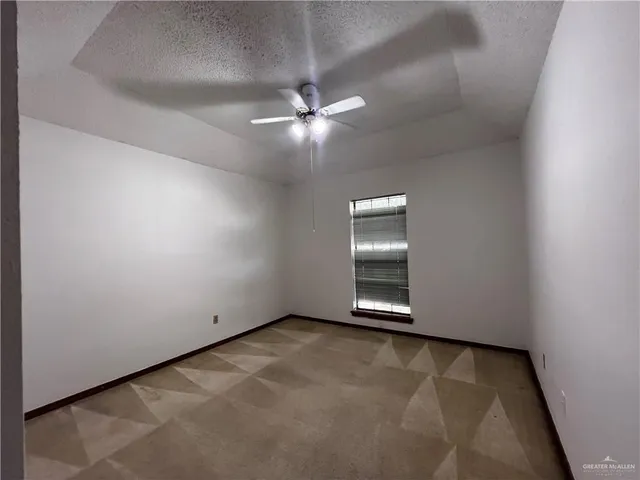 an empty room with closet and a ceiling fan