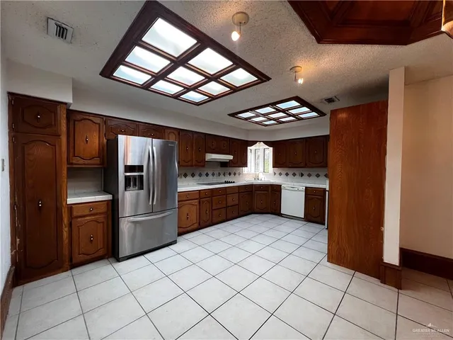 a kitchen with stainless steel appliances kitchen island granite countertop a stove cabinets and refrigerator