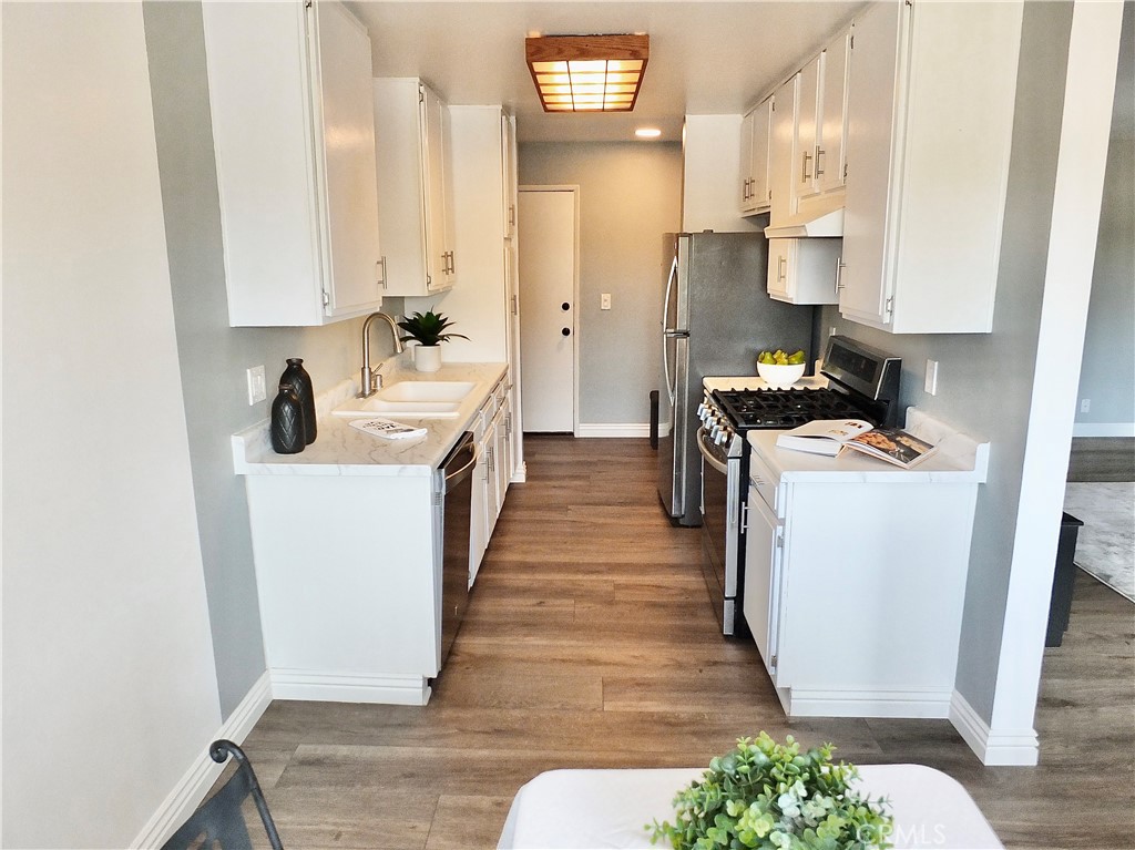 4591 Orange Avenue, Unit 306 Long Beach, CA 90807 - Photo 13 of 34 a kitchen with white cabinets and sink