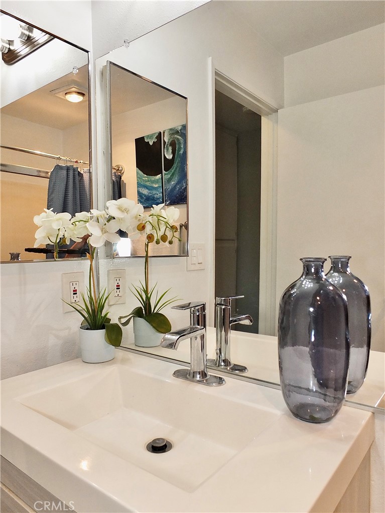 4591 Orange Avenue, Unit 306 Long Beach, CA 90807 - Photo 17 of 34 a closeup of a sink with a potted plant and mirror