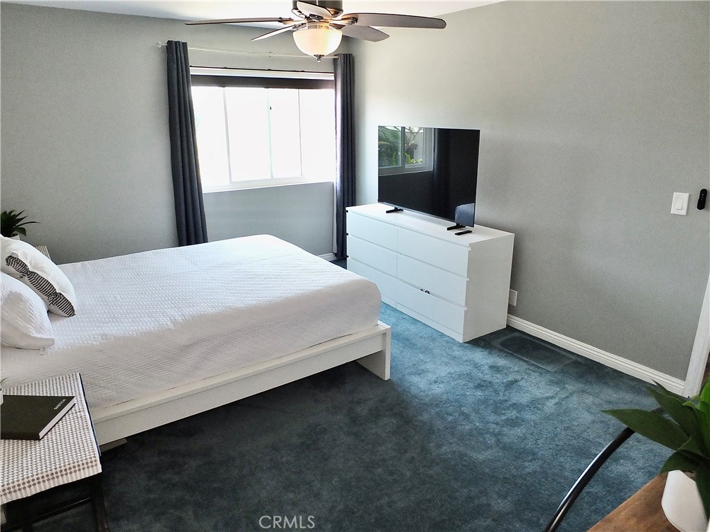 4591 Orange Avenue, Unit 306 Long Beach, CA 90807 - Photo 19 of 34 a bedroom with a bed and a flat tv screen on the dresser