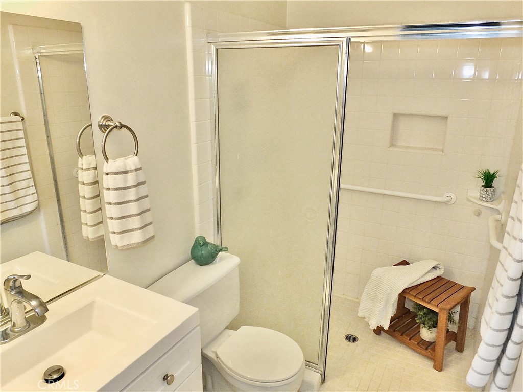 4591 Orange Avenue, Unit 306 Long Beach, CA 90807 - Photo 24 of 34 a bathroom with a sink mirror vanity and toilet