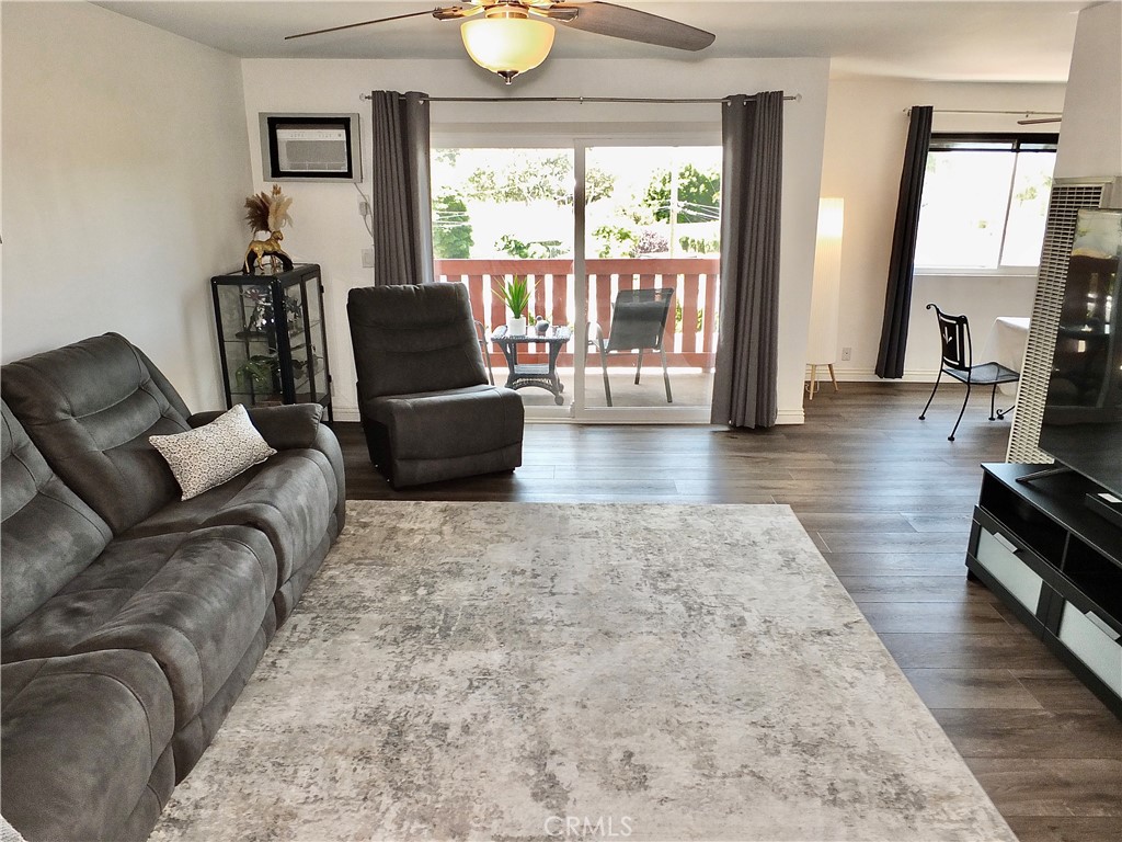 4591 Orange Avenue, Unit 306 Long Beach, CA 90807 - Photo 4 of 34 a living room with furniture and a flat screen tv
