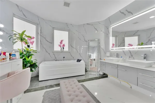 a bathroom with a tub sink and mirror