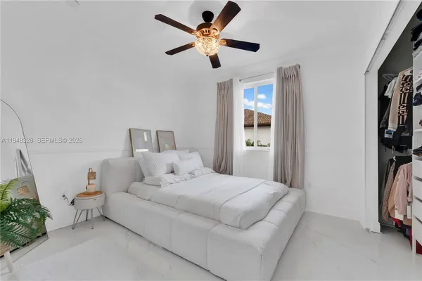 a bedroom with a bed and a ceiling fan