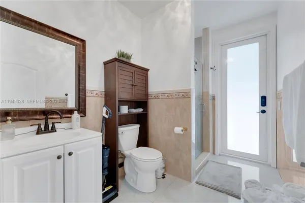 a bathroom with a toilet sink vanity and mirror