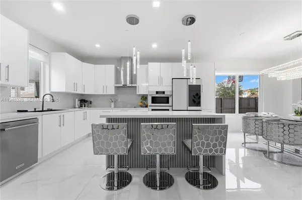 a kitchen with stainless steel appliances granite countertop a sink and a refrigerator