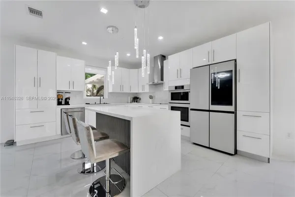 a kitchen with white cabinets and stainless steel appliances