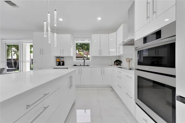 a large white kitchen with a large window