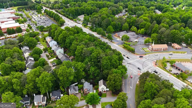 an aerial view of residential houses with outdoor space and trees all around