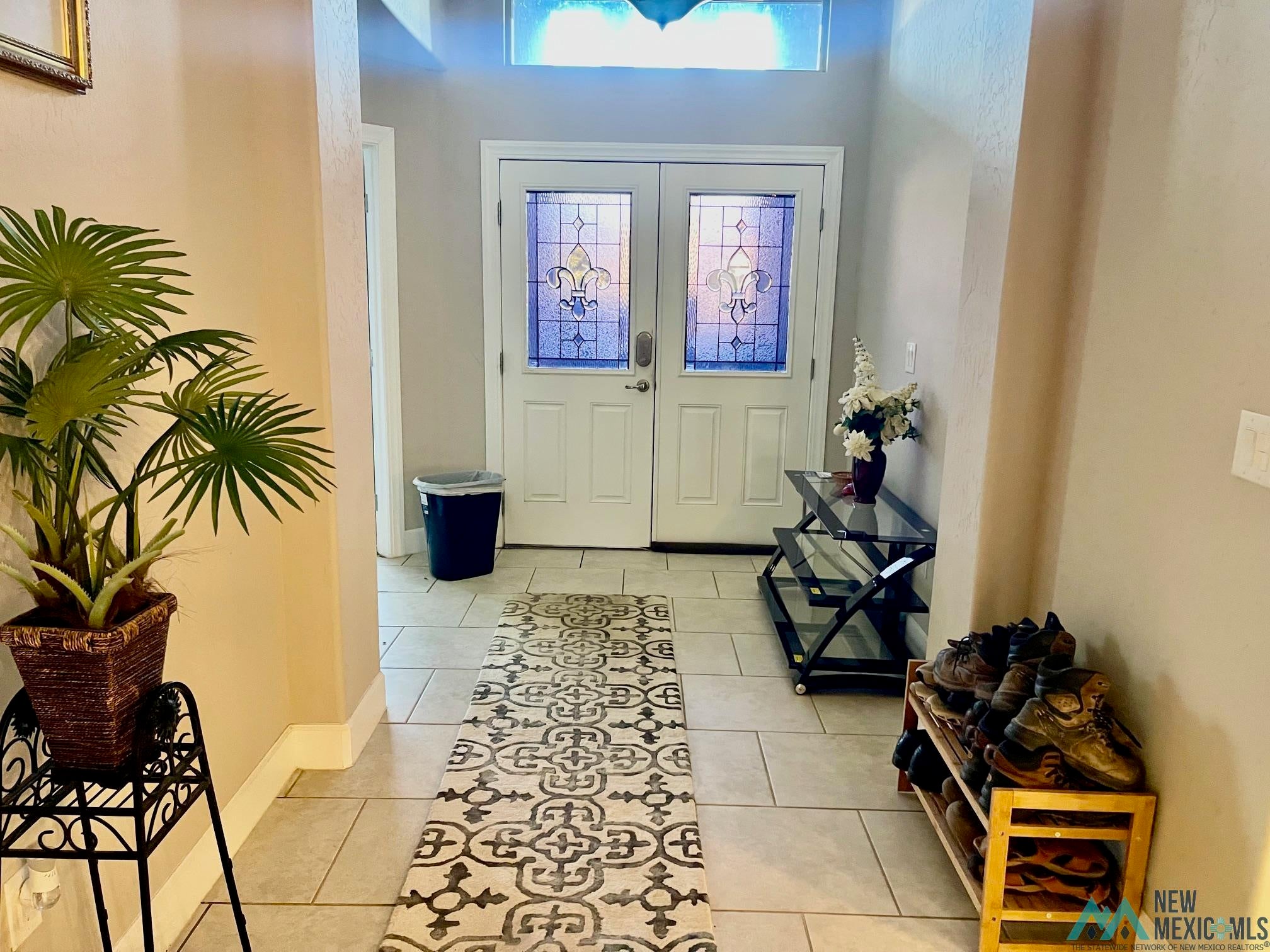 Entryway featuring french doors and light tile patterned floors