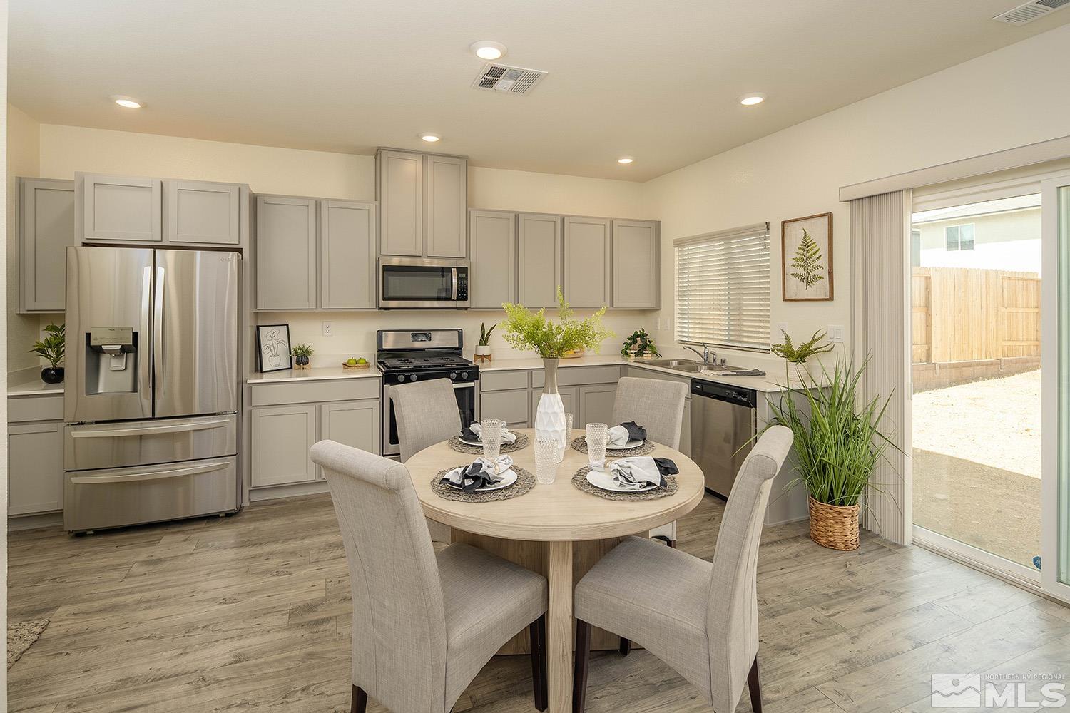 8831 Gazing Star Drive Reno, NV 89506 - Photo 3 of 27 a kitchen with a refrigerator a stove a dining table and chairs