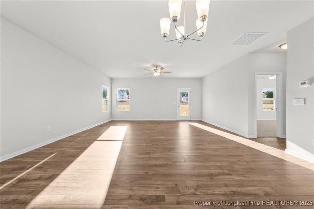 266 Happy Trail Road Aberdeen, NC 28315 - Photo 12 of 34 a view of empty room with wooden floor and kitchen view