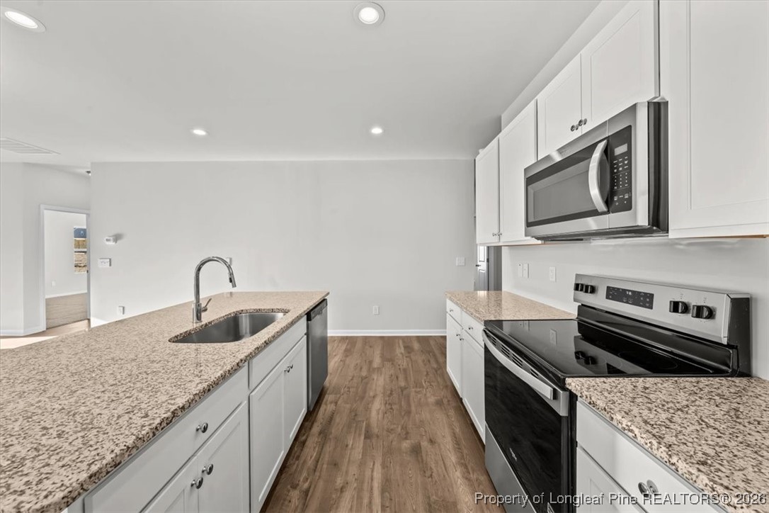 266 Happy Trail Road Aberdeen, NC 28315 - Photo 17 of 34 a kitchen with stainless steel appliances granite countertop a sink and stove top oven