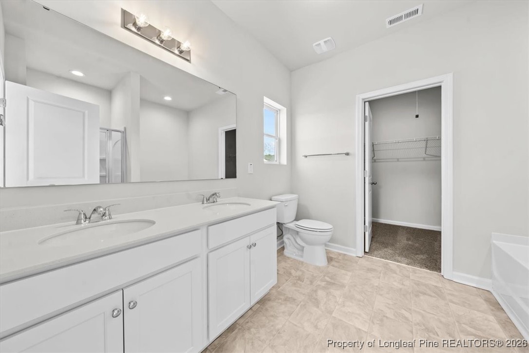 266 Happy Trail Road Aberdeen, NC 28315 - Photo 30 of 34 a bathroom with a double vanity sink mirror double and toilet