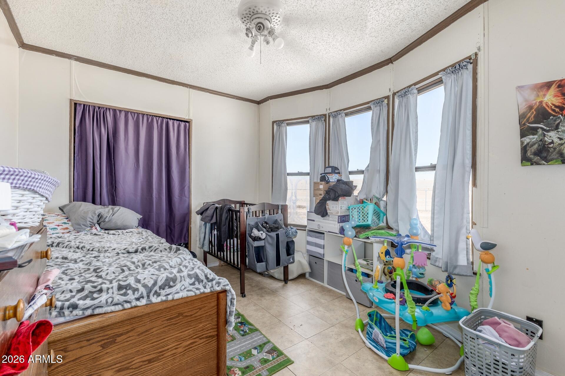 20917 West Black Butte Road Wittmann, AZ 85361 - Photo 12 of 22 a bedroom that has a bed and a table in it