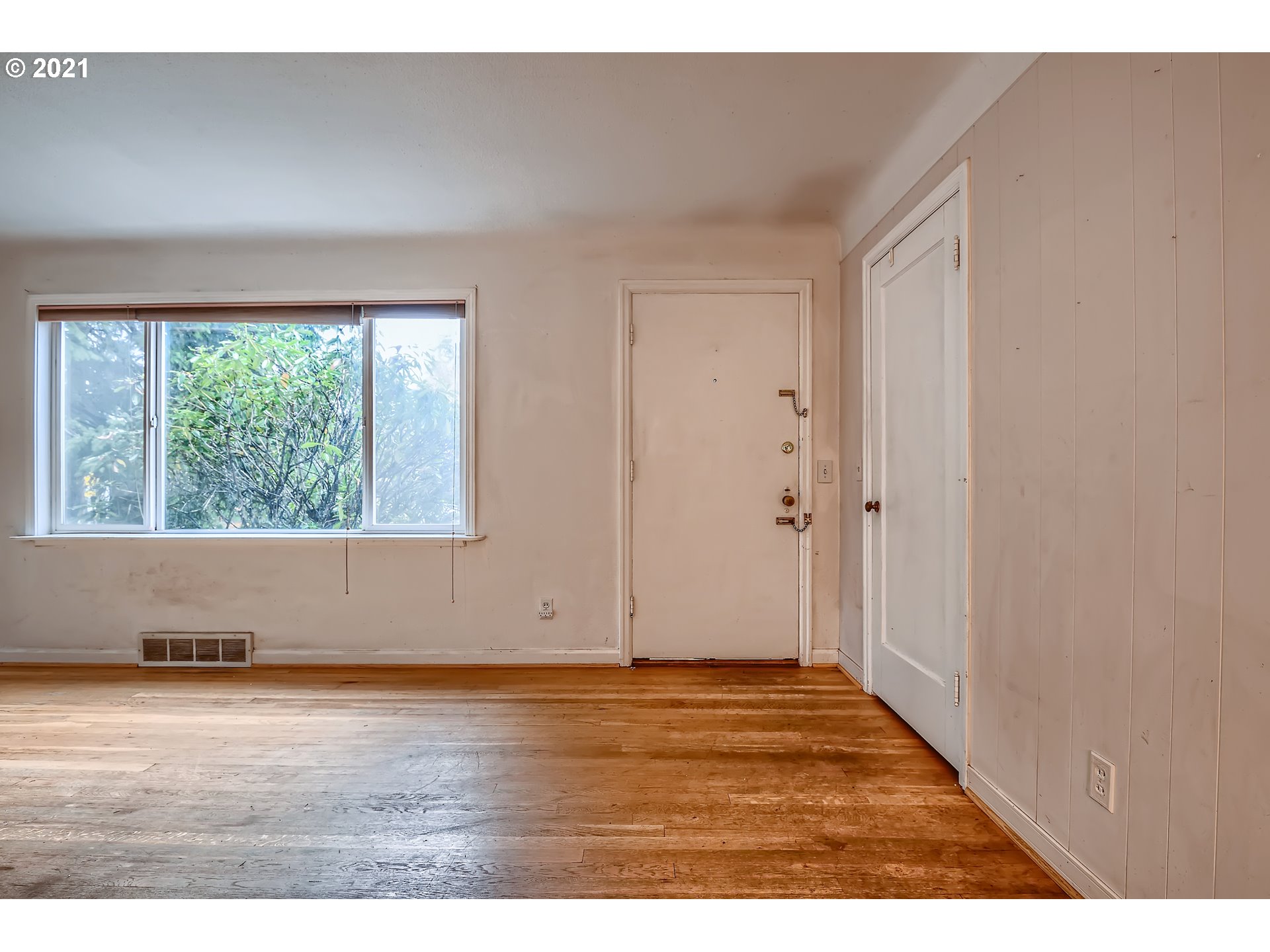 12044 Southeast Foster Road Portland, OR 97266 - Photo 4 of 28 a view of an empty room with wooden floor and a window
