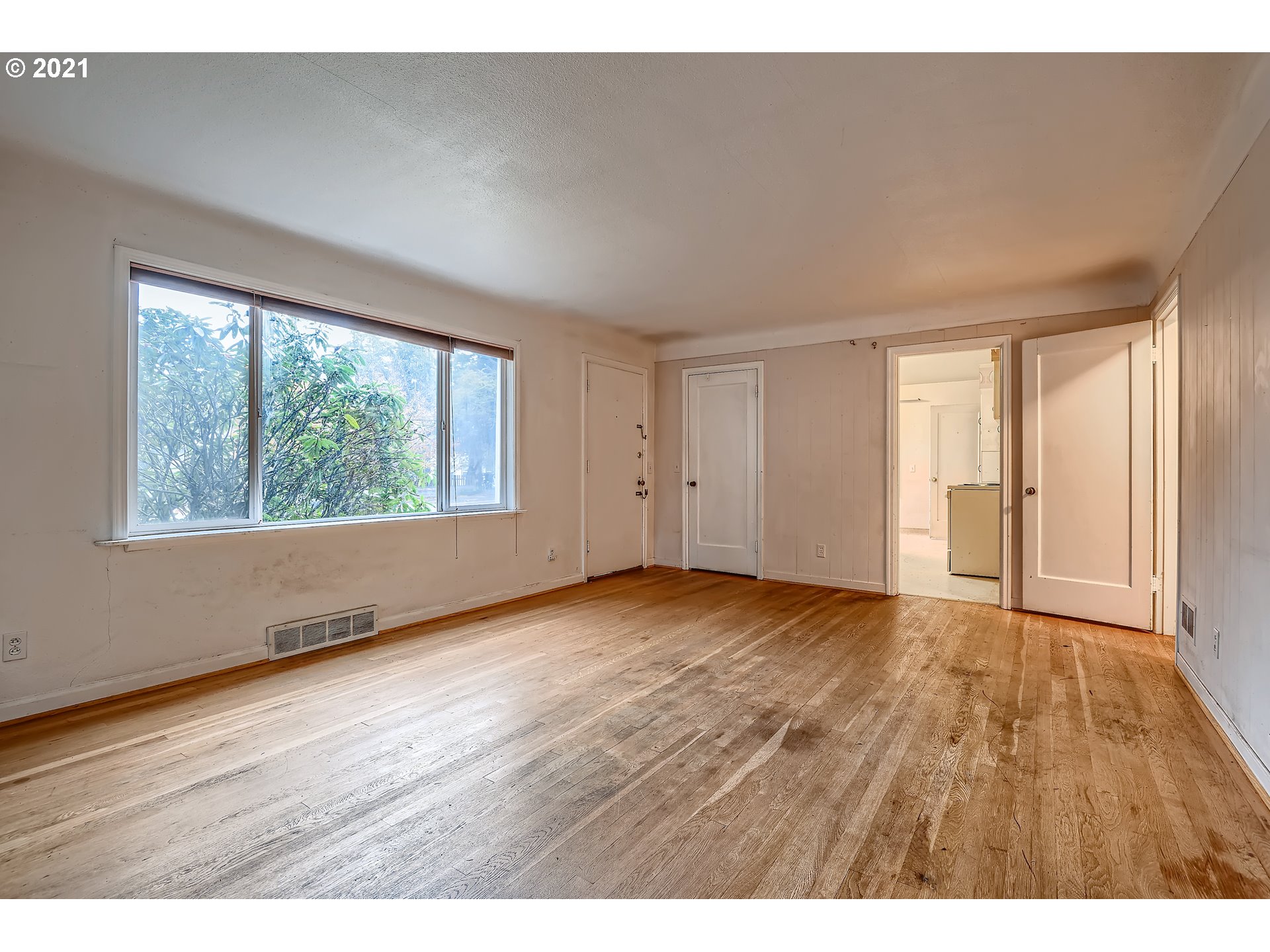 12044 Southeast Foster Road Portland, OR 97266 - Photo 7 of 28 a view of an empty room with wooden floor and a window