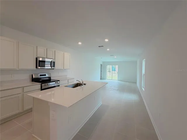 a kitchen with a sink a stove and cabinets
