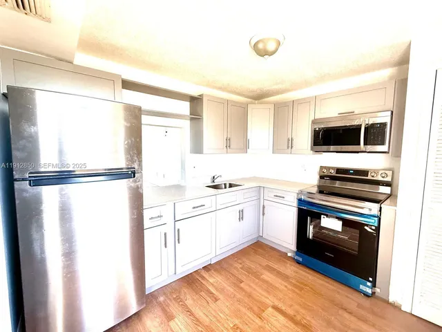 a kitchen with a refrigerator and a stove top oven