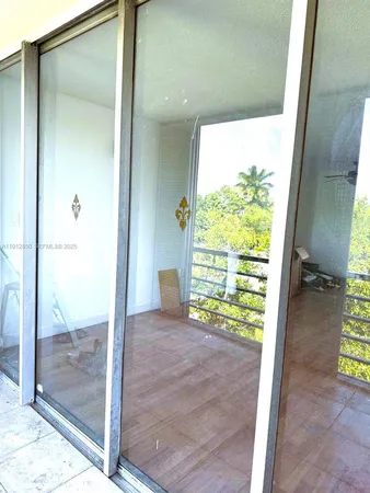 a view of a room with wooden floor and front door