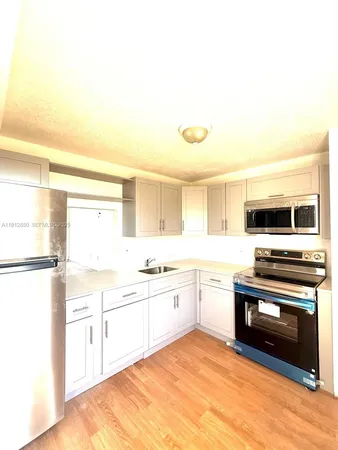 a large kitchen with cabinets and stainless steel appliances