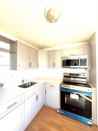 a kitchen with stainless steel appliances a stove a sink and a microwave