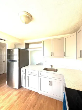 a kitchen with a sink cabinets and a refrigerator